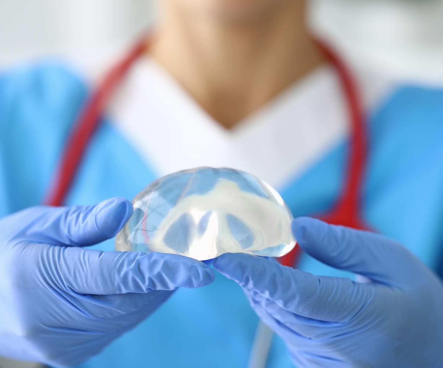 surgeon holding a breast implant